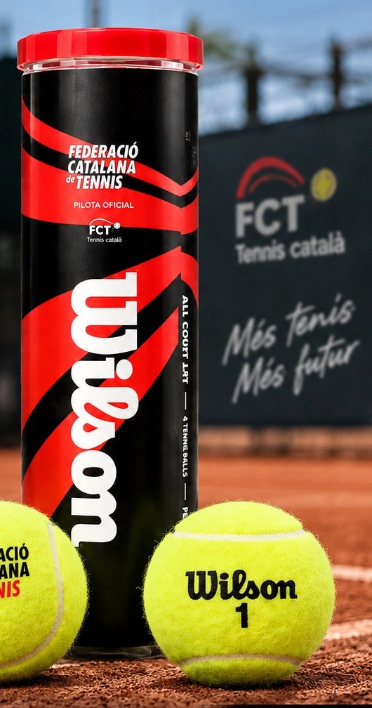 Bote de pelotas Wilson con la imagen de la Federació Catalana de Tennis, en una pista de tierra batida